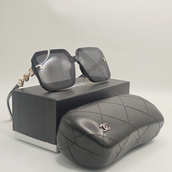 Sleek Black Chanel Sunglasses with Golden Hues - Picture 1 of 5
